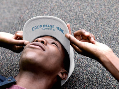Hat Mockup of a Black Guy Lying on the Ground Looking Up 11771