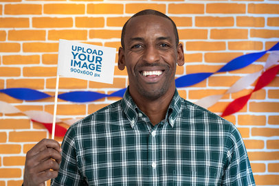 Mockup of a Smiling Man Holding a Flag at a Political Campaign Booth 