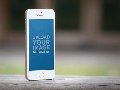 iPhone Mockup Featuring a Blurry Garden in the Background 