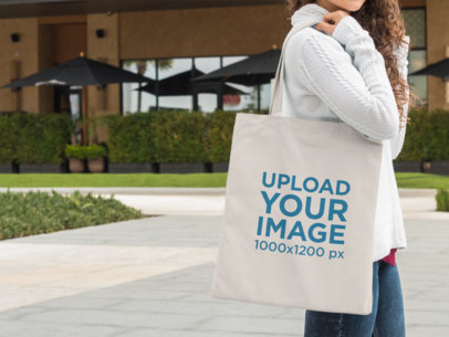 Tote Bag Mockup Carried by a Woman Waiting Outside a11576