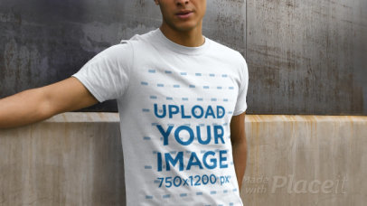 Video of a Man Wearing a T-Shirt and Posing Against a Concrete Wall