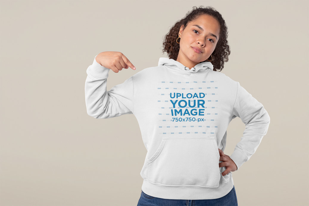 Studio Mockup of a Confident Woman Pointing at Her Hoodie 