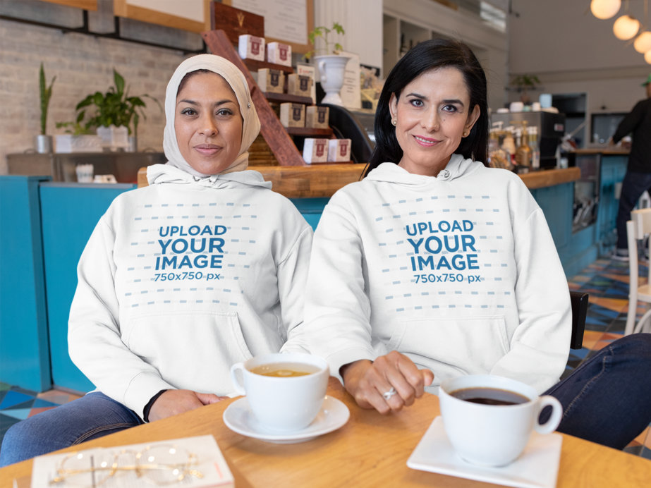 Hoodie Mockup Featuring Two Women Hanging Out at a Coffee Shop 