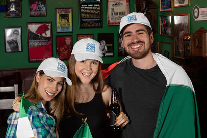 Dad Hat Mockup Featuring Three Joyful Friends Celebrating St. Patrick's Day