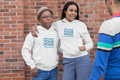Mockup of a Senior Man and a Woman Wearing Hoodies While Chatting Outside