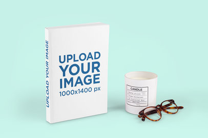 Paperback Book Mockup Featuring a Scented Candle and a Customizable Background 2896