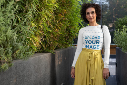 Long Sleeve T-Shirt Mockup of a Woman Walking by Some Shrubbery