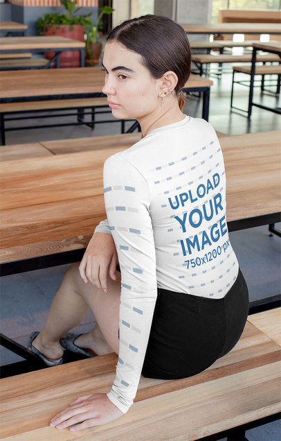 Long Sleeve T-Shirt Mockup of a Serious Woman Sitting at a Table 
