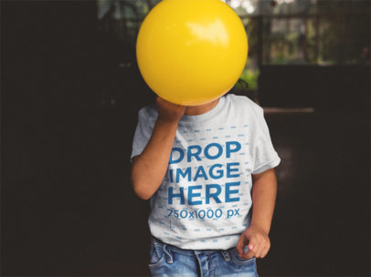 Kid's T-Shirt Mockup of a Child Covering Their Face with a Ball