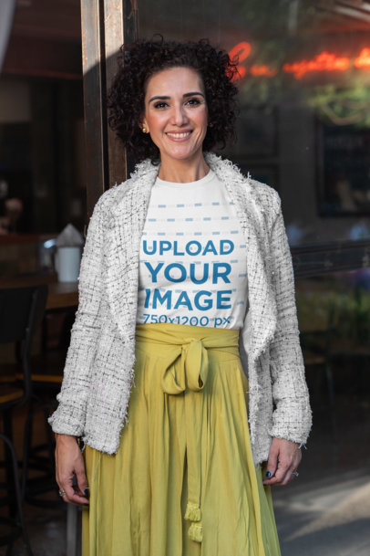 T-Shirt Mockup Featuring a Middle-Aged Woman with Curly Hair by a Restaurant Window 