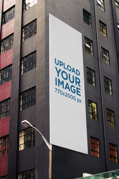 Mockup of a Vertical Billboard on a Gray Modern Building 