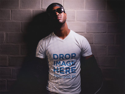 V-Neck T-Shirt Mockup of a Man Against a Wall Wearing Sunglasses