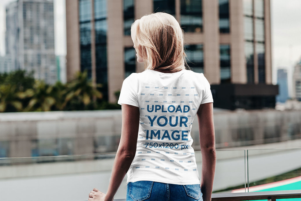 Back View Mockup of a Woman Wearing a T-Shirt in an Urban Scenario 