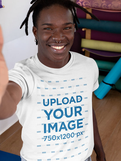 T-Shirt Mockup of a Man Taking a Selfie at a Yoga Studio