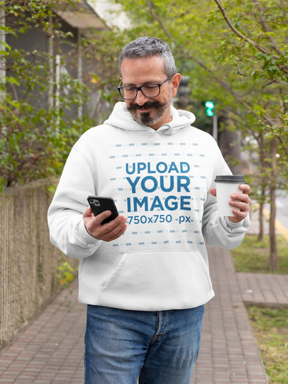 Hoodie Mockup of a Silver-Haired Man Staring at His Phone