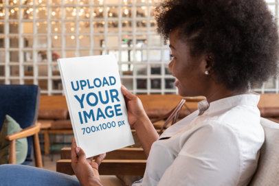 Mockup of a Young Woman Checking the Cover of a Magazine 