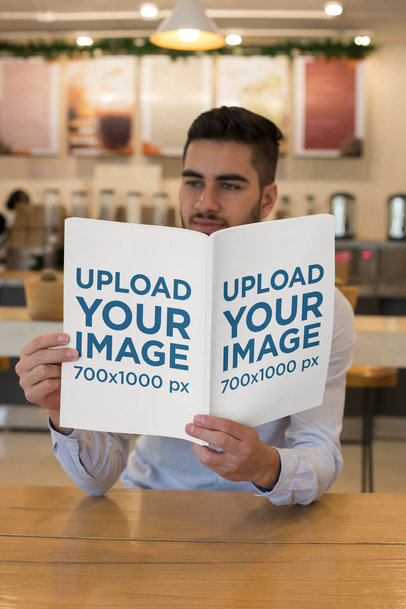 Mockup of a Young Man Reading a Magazine at a Coffee Shop