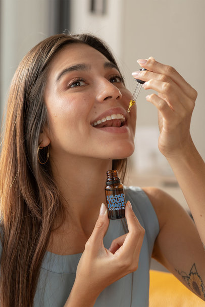 Dropper Mockup Featuring a Woman Taking CBD Oil