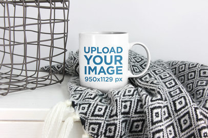 Mockup of a Coffee Mug Placed Over a Blanket 