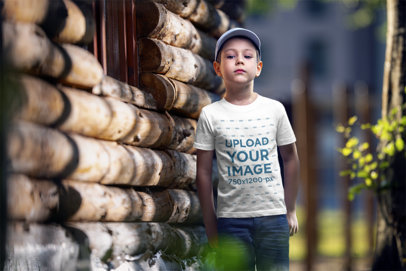 T-Shirt Mockup of a Serious Boy Next to a Cabin