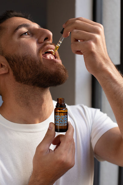 Dropper Bottle Mockup of a Man Taking CBD Oil 