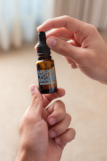 Mockup of a Man Holding a CBD Oil Dropper Bottle  