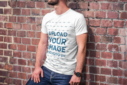 Mockup of a Bearded Man Wearing a T-Shirt and Leaning on a Brick Wall 