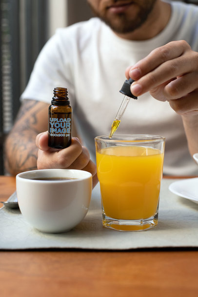 Dropper Bottle Mockup of a Man Using His CBD Oil