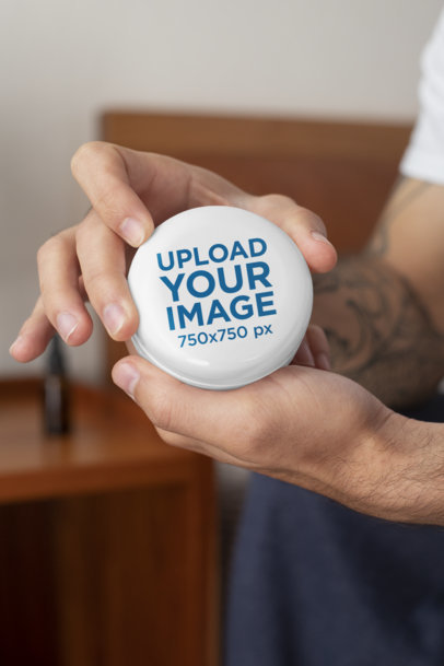 Mockup of a Tattooed Man Holding a 2 oz CBD Jar 32105