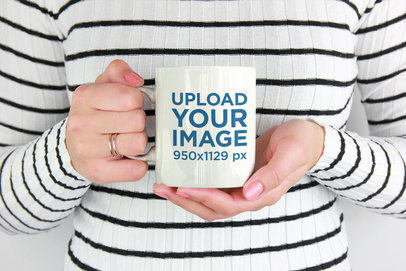 Mockup of a Woman Wearing Stripes Holding an 11 oz Mug