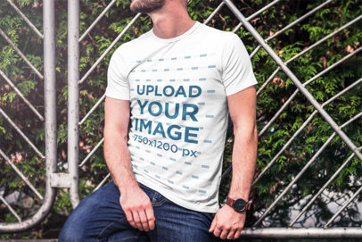 Mockup of a Bearded Man Wearing a T-Shirt and Leaning on a Metal Fence 