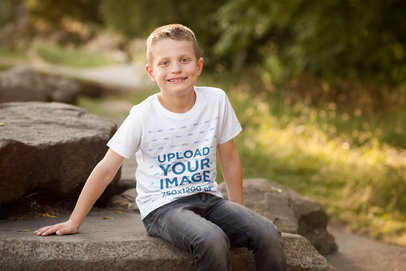 T-Shirt Mockup Featuring a Smiling Boy in Nature