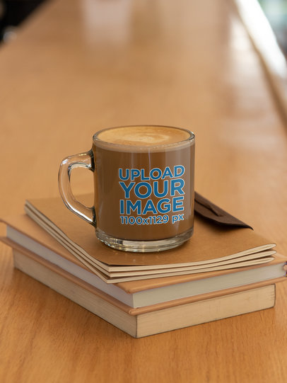 Mockup of a Glass Mug Placed Over Some Books 