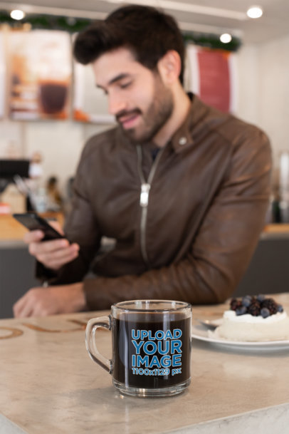 Clear Mug Mockup of a Bearded Man Using His Phone at a Cafe 31776