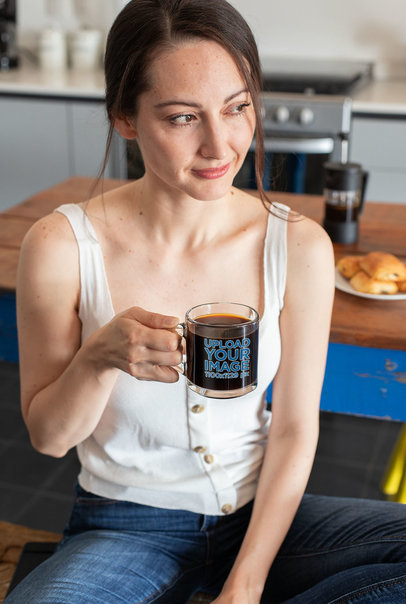 Clear Mug Mockup of a Woman Enjoying a Coffee in Her Kitchen