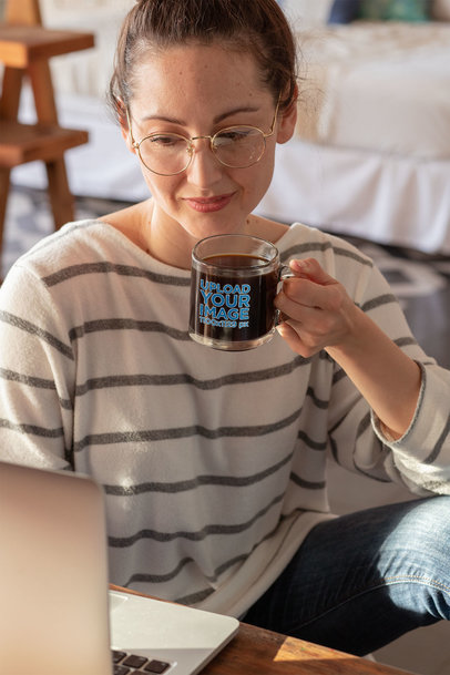 11 oz Glass Mug Mockup Featuring a Woman on Her Computer