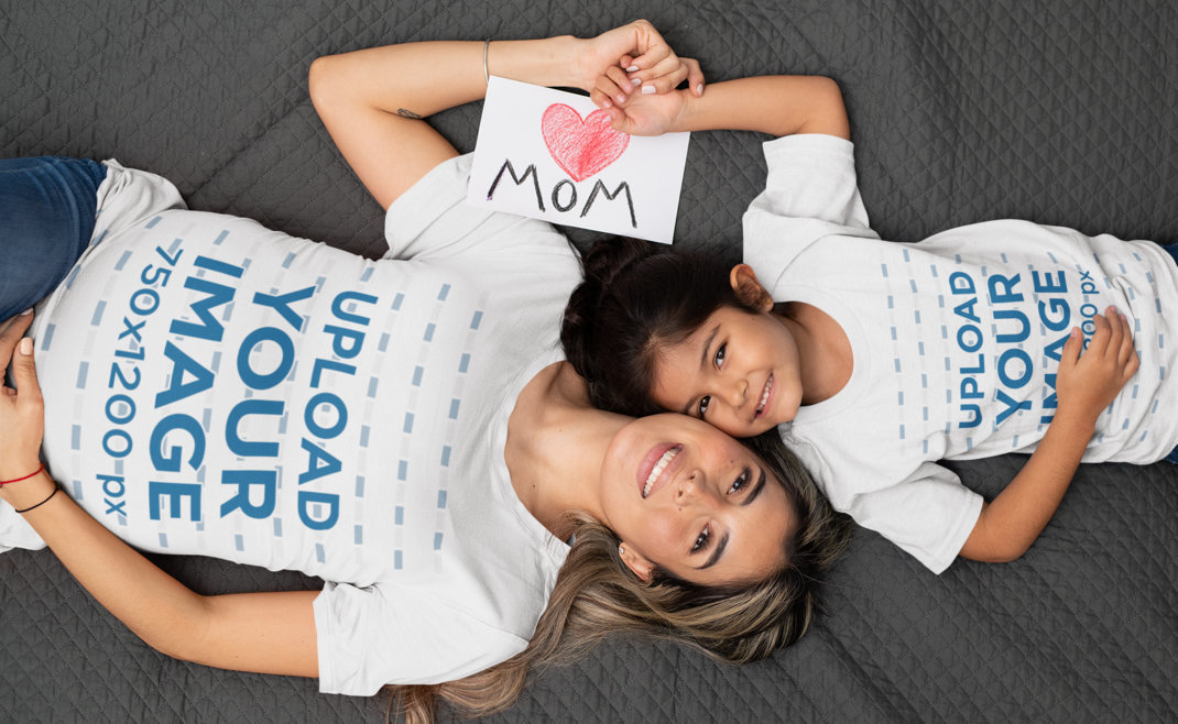 T-Shirt Mockup Featuring a Mom and Her Little Daughter Lying Down