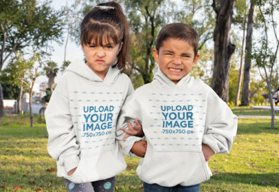 Mockup of Brother and Sister Wearing Hoodies at the Park
