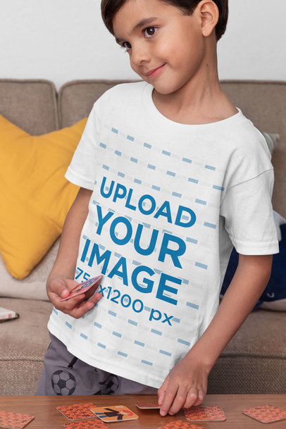 T-Shirt Mockup Featuring a Kid Playing a Memory Card Game 