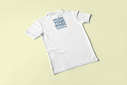 Back View Mockup Featuring a Polo Shirt Placed Over a Plain Color Surface 