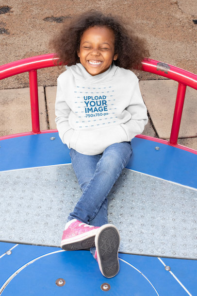 Mockup of a Happy Girl Wearing a Hoodie at a Playground 