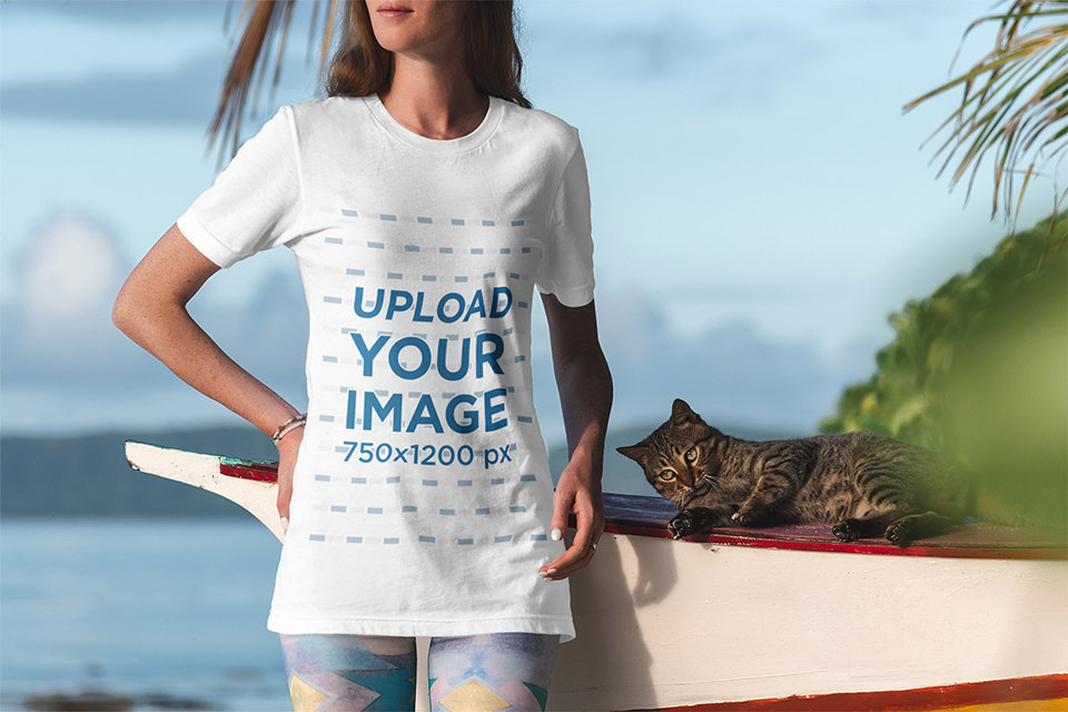 T-Shirt Mockup of a Woman Standing By the Sea with a Cat