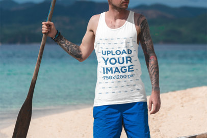 Tank Top Mockup of a Tattooed Man Holding an Oar By the Sea