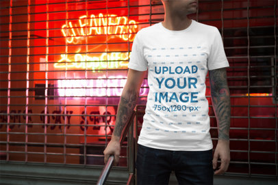 Mockup of a Man Wearing a T-Shirt Featuring Neon Signs in the Background