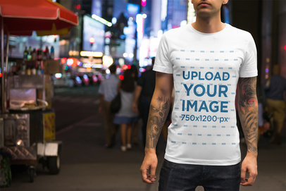 T-Shirt Mockup of a Tattooed Man on a Busy Street