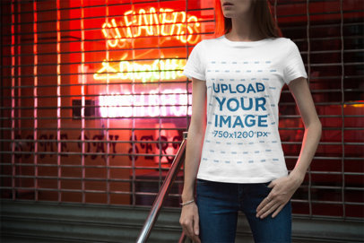 Mockup of a Woman Wearing a T-Shirt with Neon Signs in the Background 3356-el1