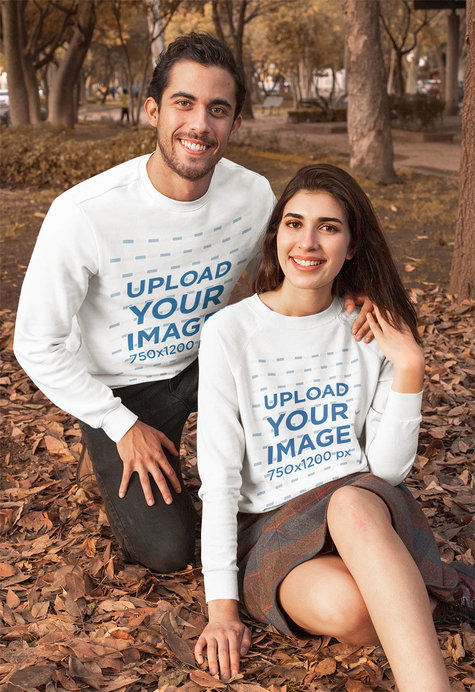 Mockup of a Couple Wearing Customizable Crewneck Sweatshirts at a Park During Autumn 