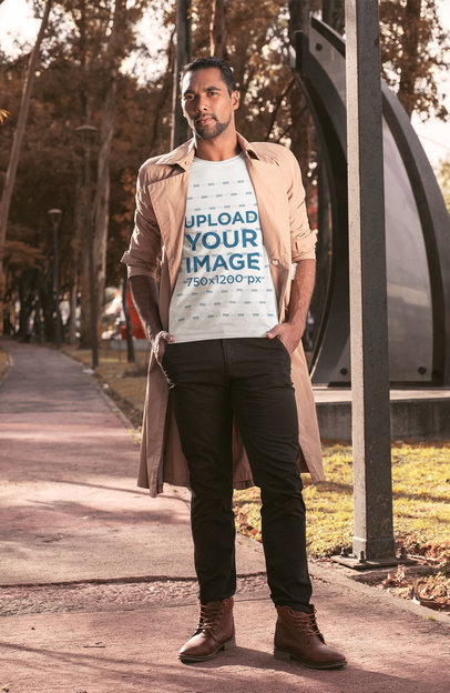 T-Shirt Mockup of a Man Wearing a Trench Coat at a Park