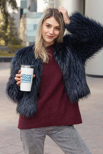 Mockup of a Stylish Woman Holding a Travel Mug