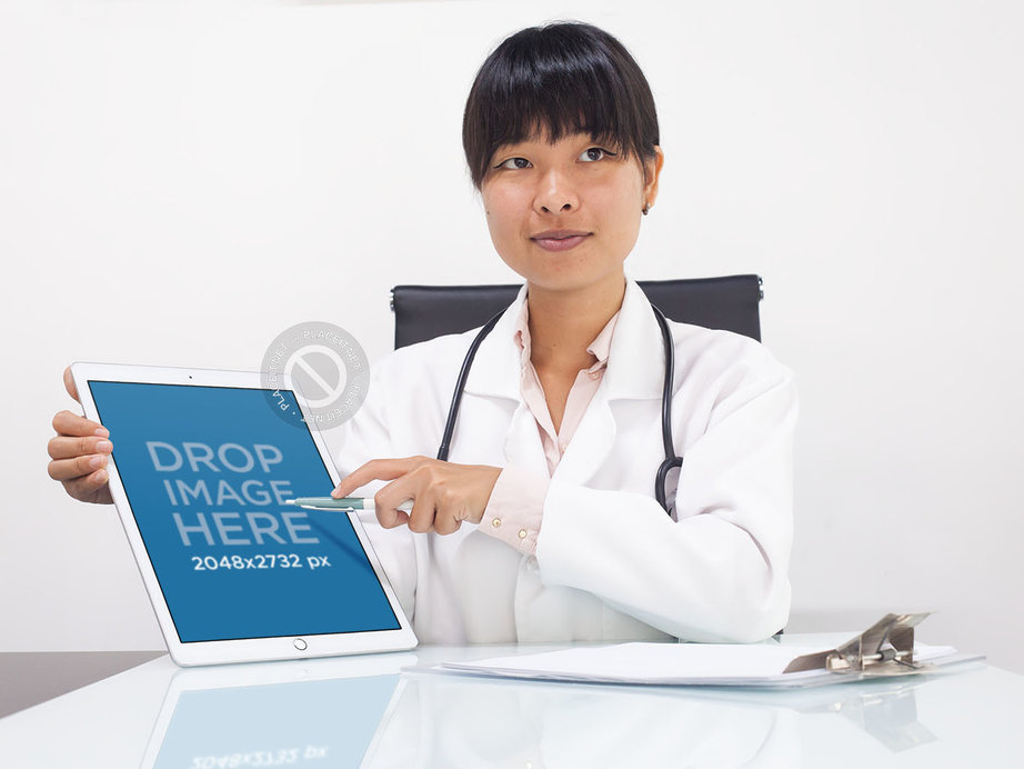 Doctor Pointing at Her iPad Pro in Her Office Mockup